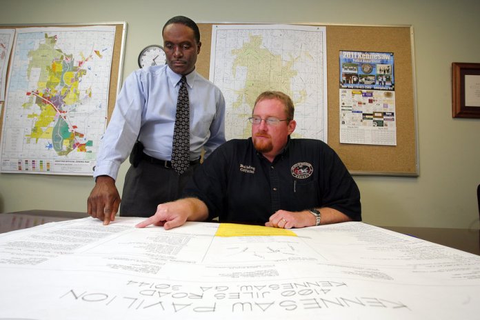 Kennesaw Zoning and Planning Administrator Darryl Simmons goes over plans for the city with building official Mark Rice. Photo by Alicia Newton